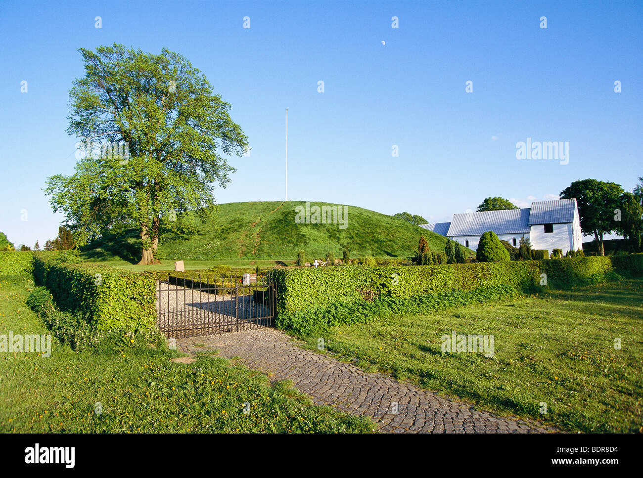 Eine Kirche und ein Tumulus, Jelling, Jütland, Dänemark. Stockfoto