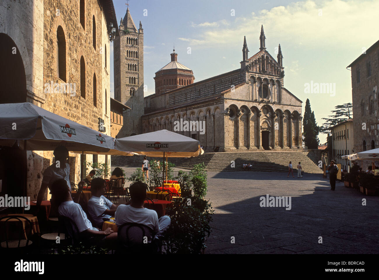 Menschen im Café und hinter ist der Duomo San Cerbone in Piazza Garibaldi, Massa Marittima, Toskana, Italien Stockfoto