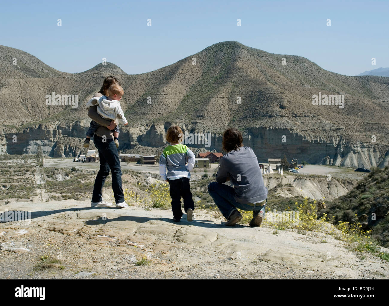 junge Familie, die auf der Suche nach unten auf eine gefälschte Cowboy-Dorf in Spanien Stockfoto