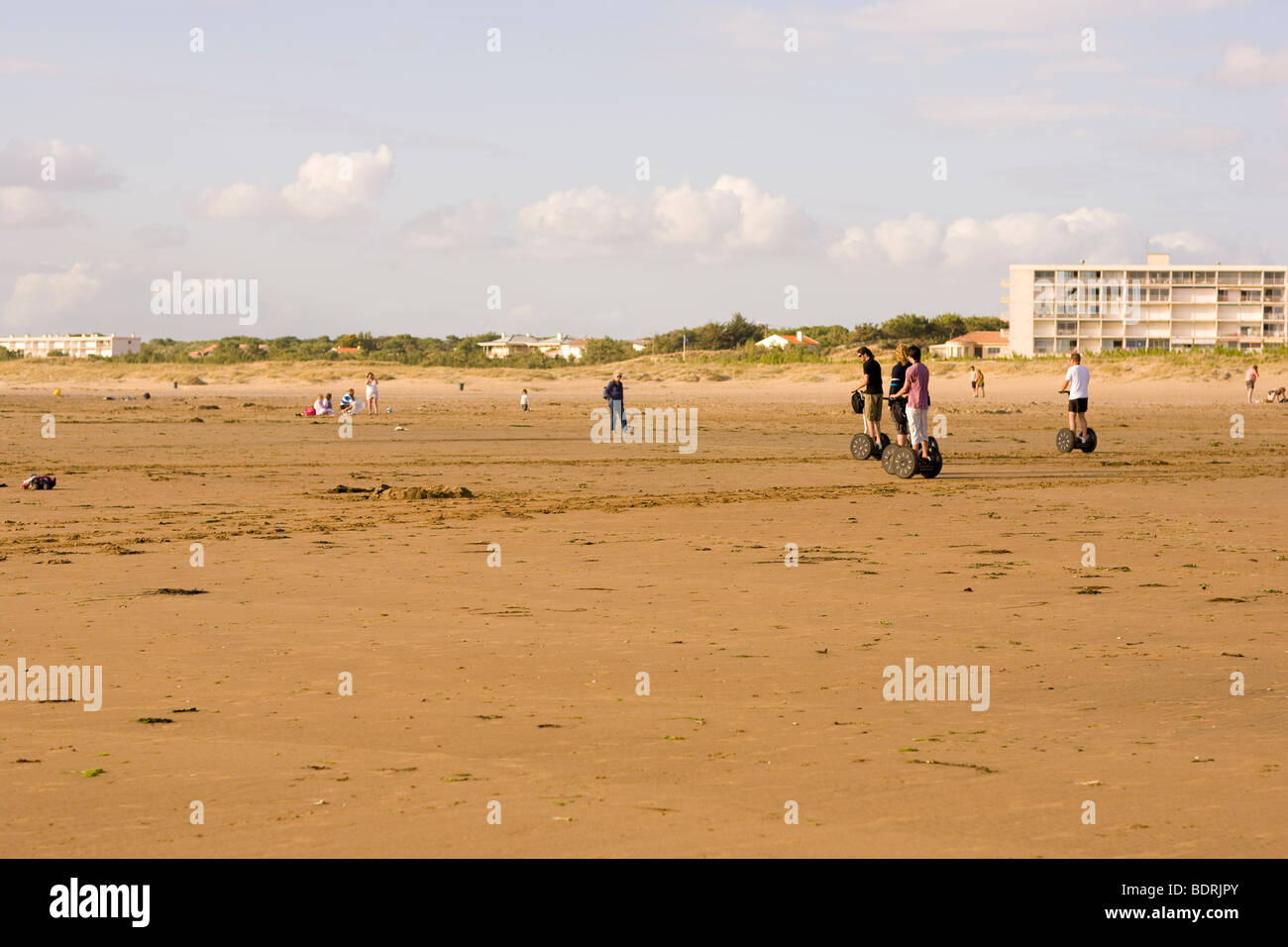 Eine Gruppe von Menschen, die Segways am Strand Reiten. Stockfoto