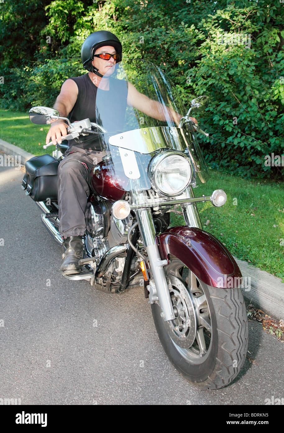 Ein Mann mittleren Alters ist ein Motorrad fahren. Stockfoto