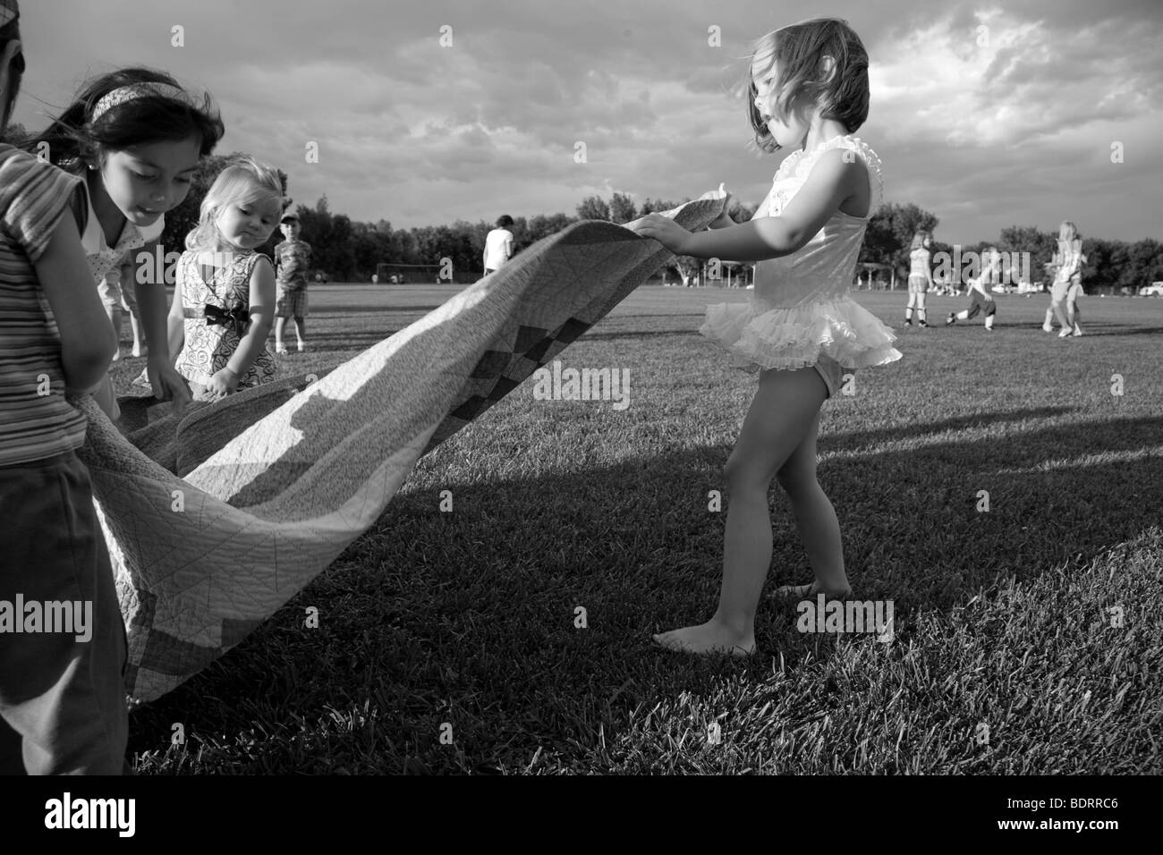 Schwarz / weiß Bild von Mädchen ziehen Decke im park Stockfoto