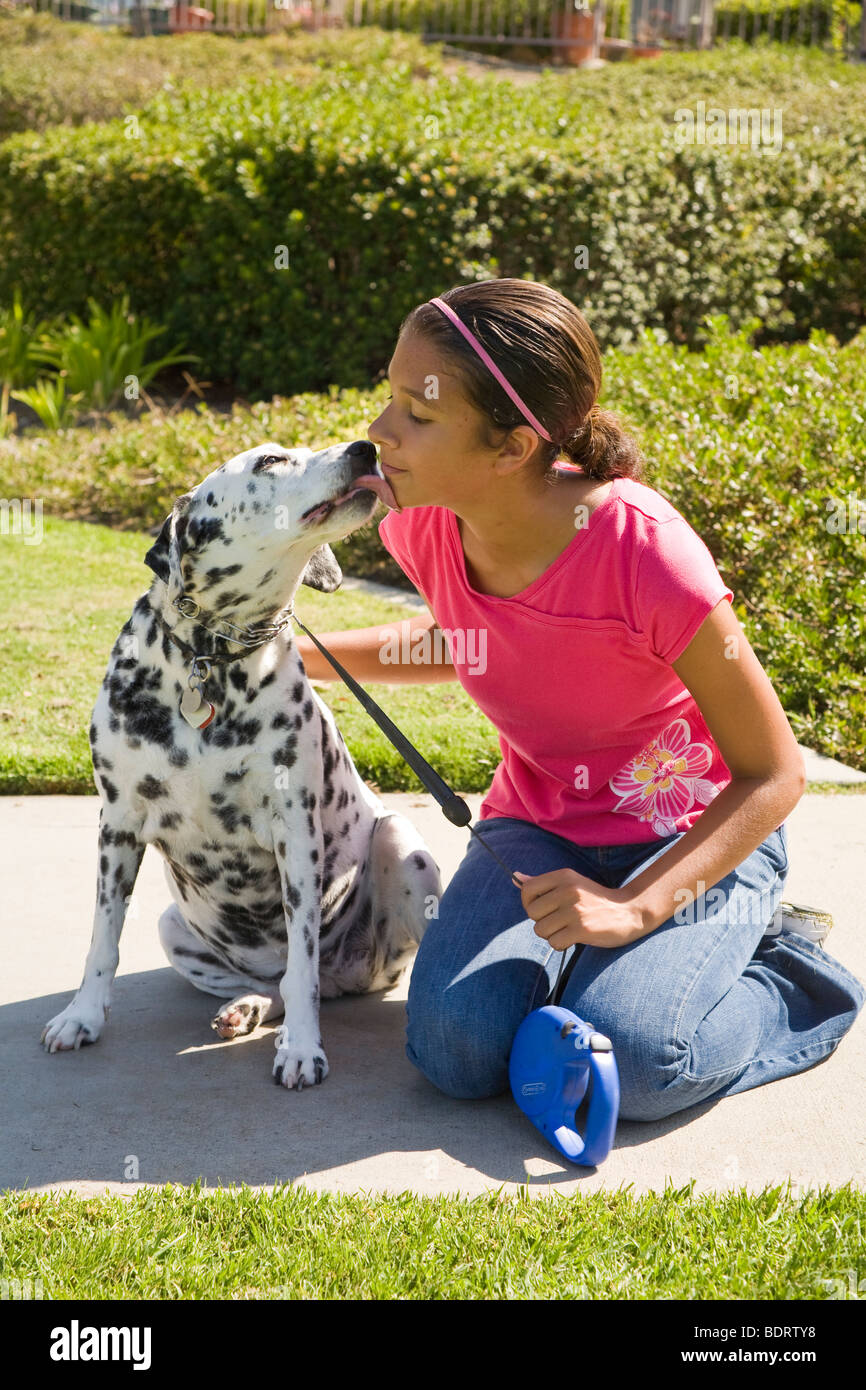 Hund Mädchen 12-14 Jahre alten Jahre Wange pet Dalmatinischen licks lecken Zuneigung Eigentümer ruht ruhenden Kindes spielen spielt Hund Vorderansicht Seite © Myrleen Pearson Stockfoto