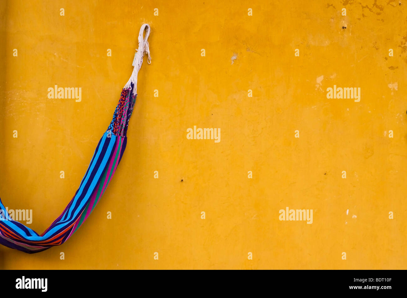 Hängematte aufgehängt an eine alte gelbe gold farbigen Wand in Cartagena, Kolumbien Stockfoto