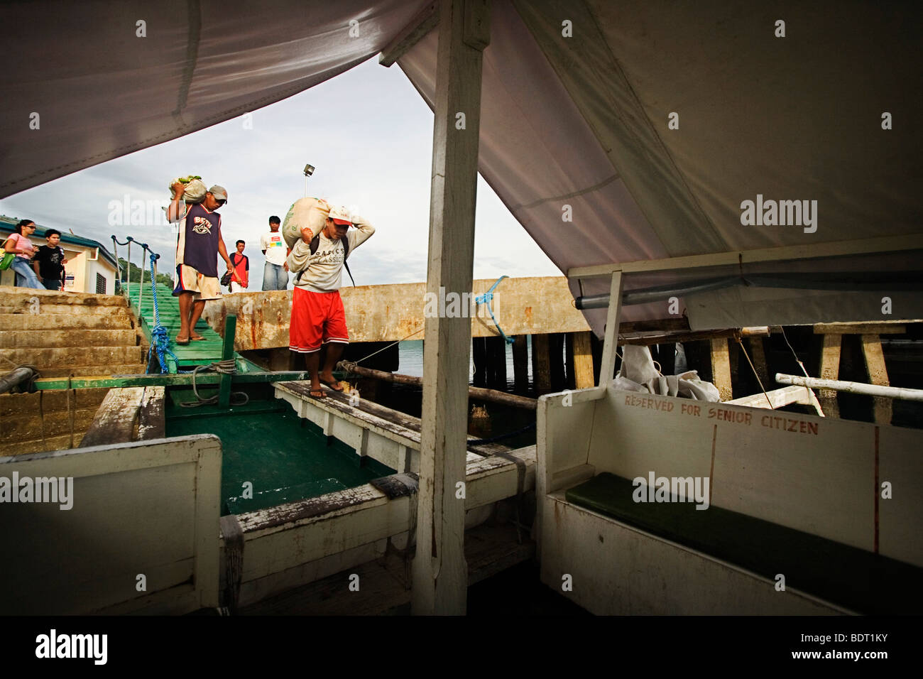 Männer laden ein Pumpboat mit waren für einen Ausflug nach Coron Island. Stockfoto