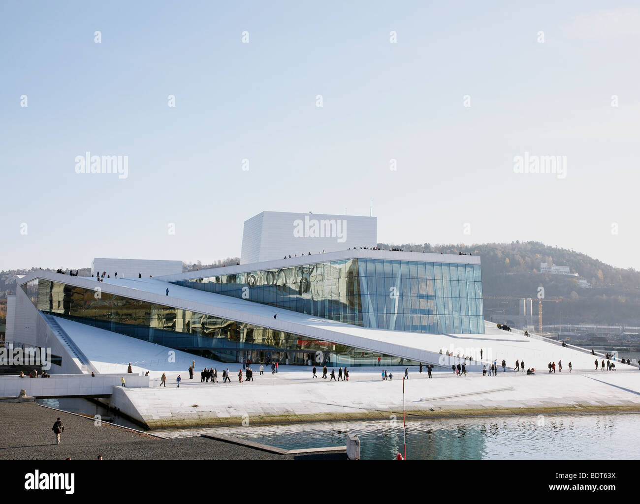 Touristen gehen um das Opernhaus von Oslo äußere Stockfoto
