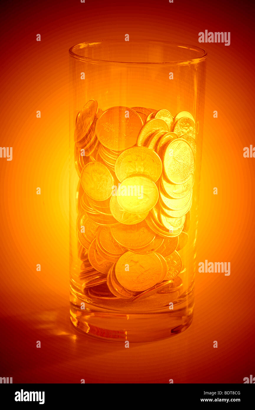 Glas voller Münzen und goldenen Glanz Stockfoto
