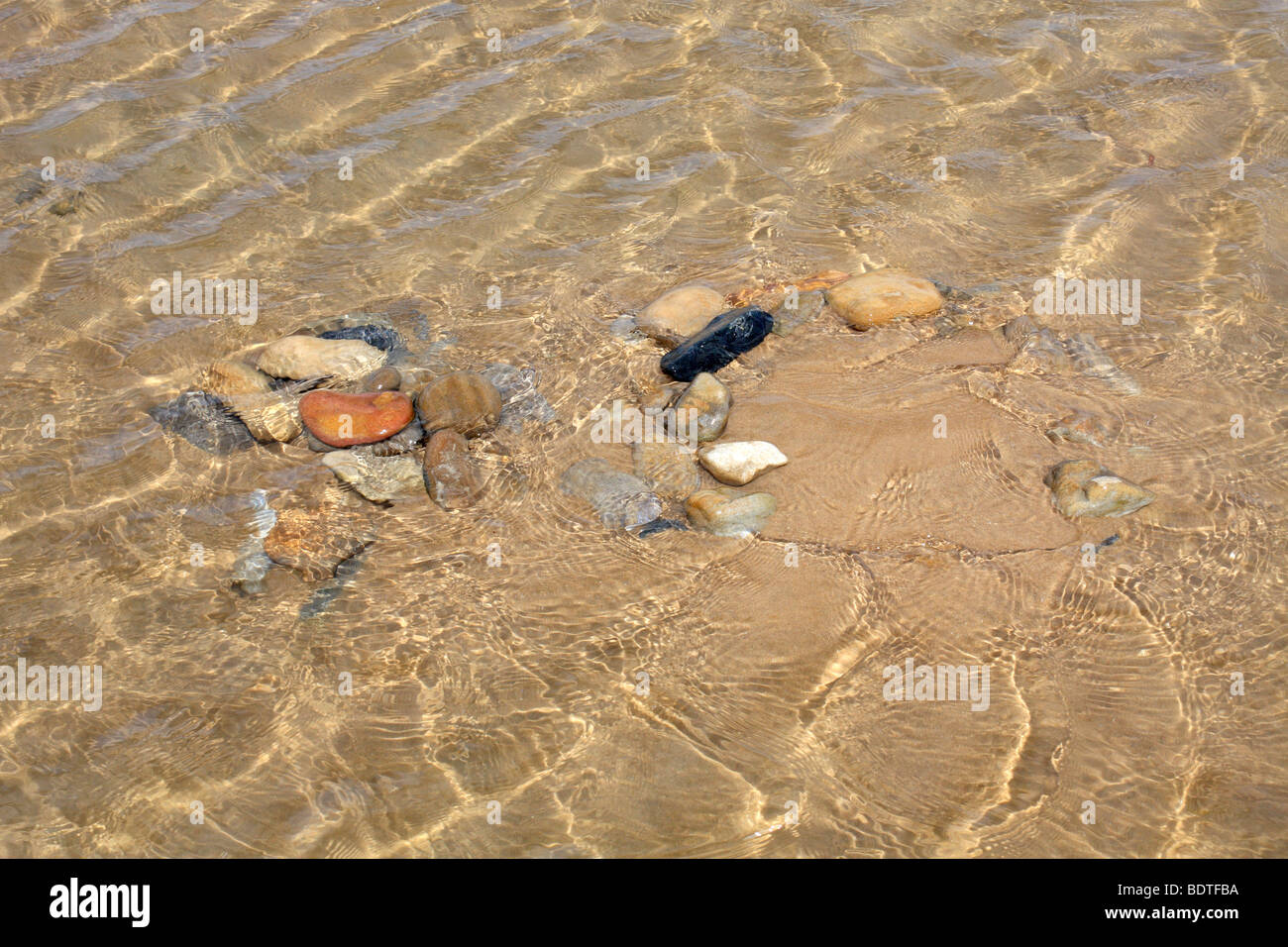 Wellen und Kieselsteine im klaren Meerwasser am Sandstrand, Omaha-Beach Colleville-Sur-Mer, Normandie Frankreich Stockfoto