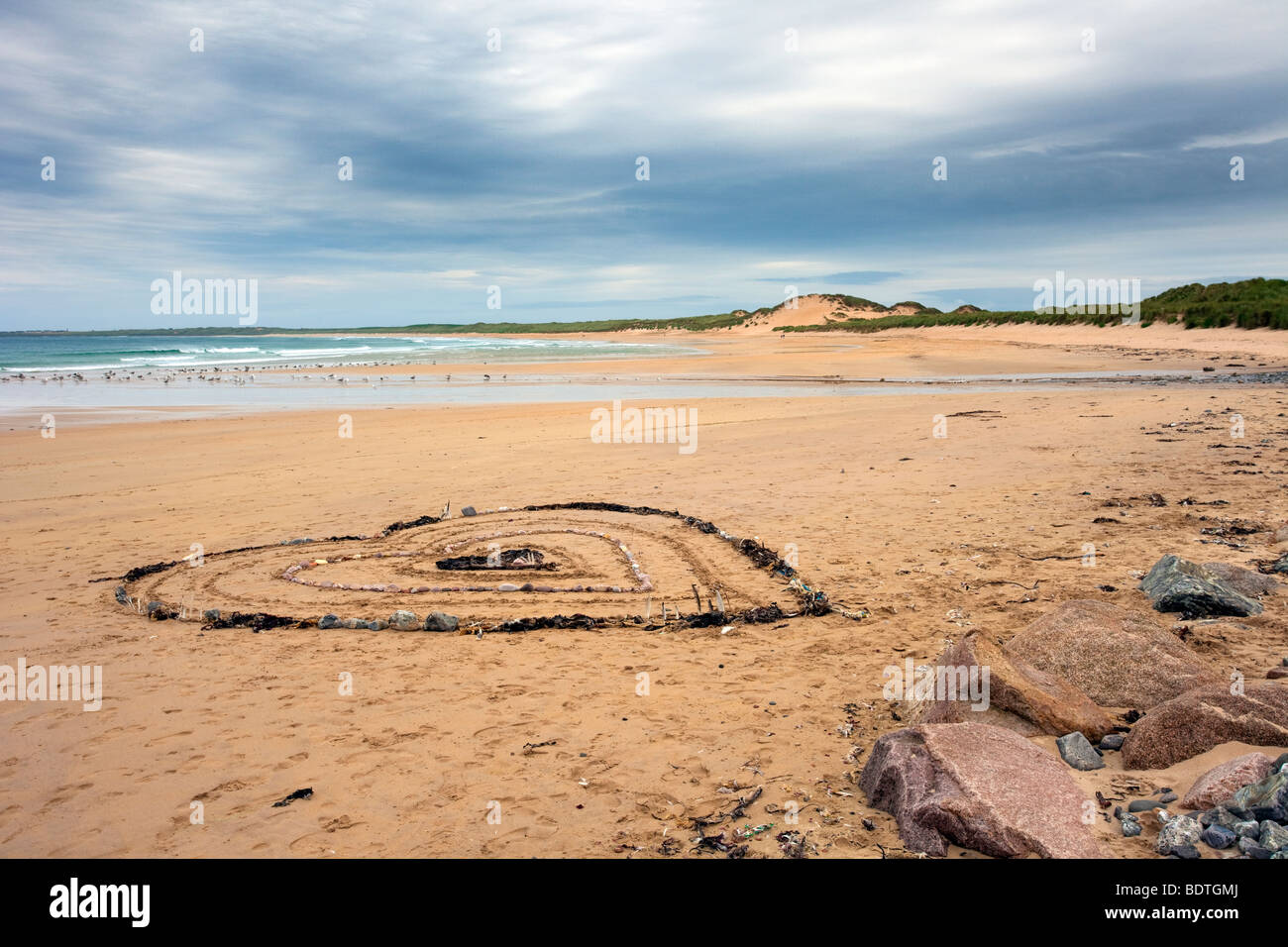 Herzförmiges Muster aus Algen und Steinen; Strandkunst und Sanddünen Küstenlandschaft in Fraserburgh Bay, Aberdeenshire, Schottland, Großbritannien. Stockfoto