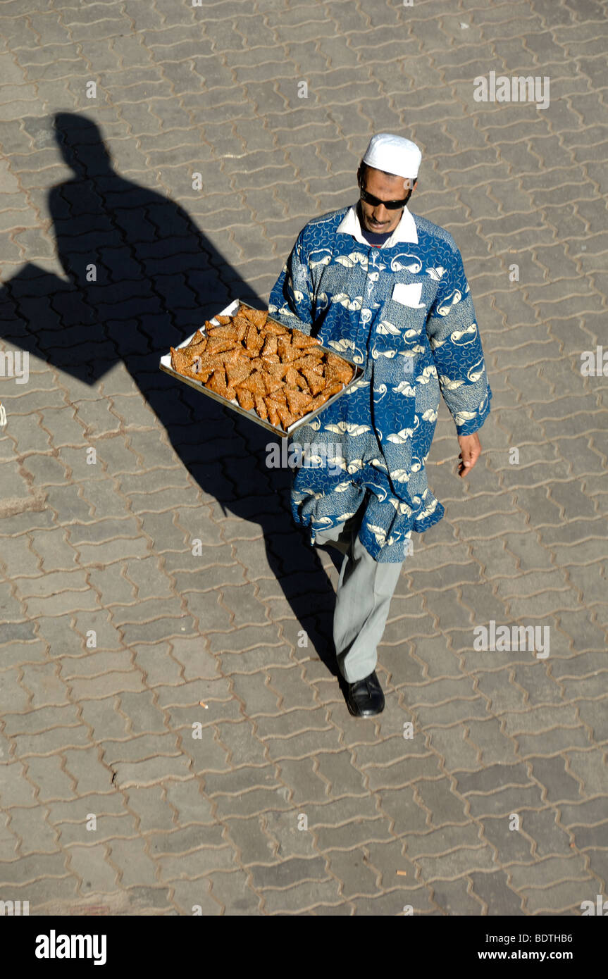 Marokkanische süße Verkäufer trägt ein Tablett von Kuchen oder klebrigem Gebäck in den Place Aux Epices, Marrakesch, Marokko Stockfoto