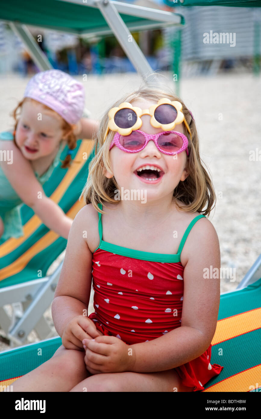 Mädchen am Strand tragen zwei Paar Sonnenbrillen Stockfoto