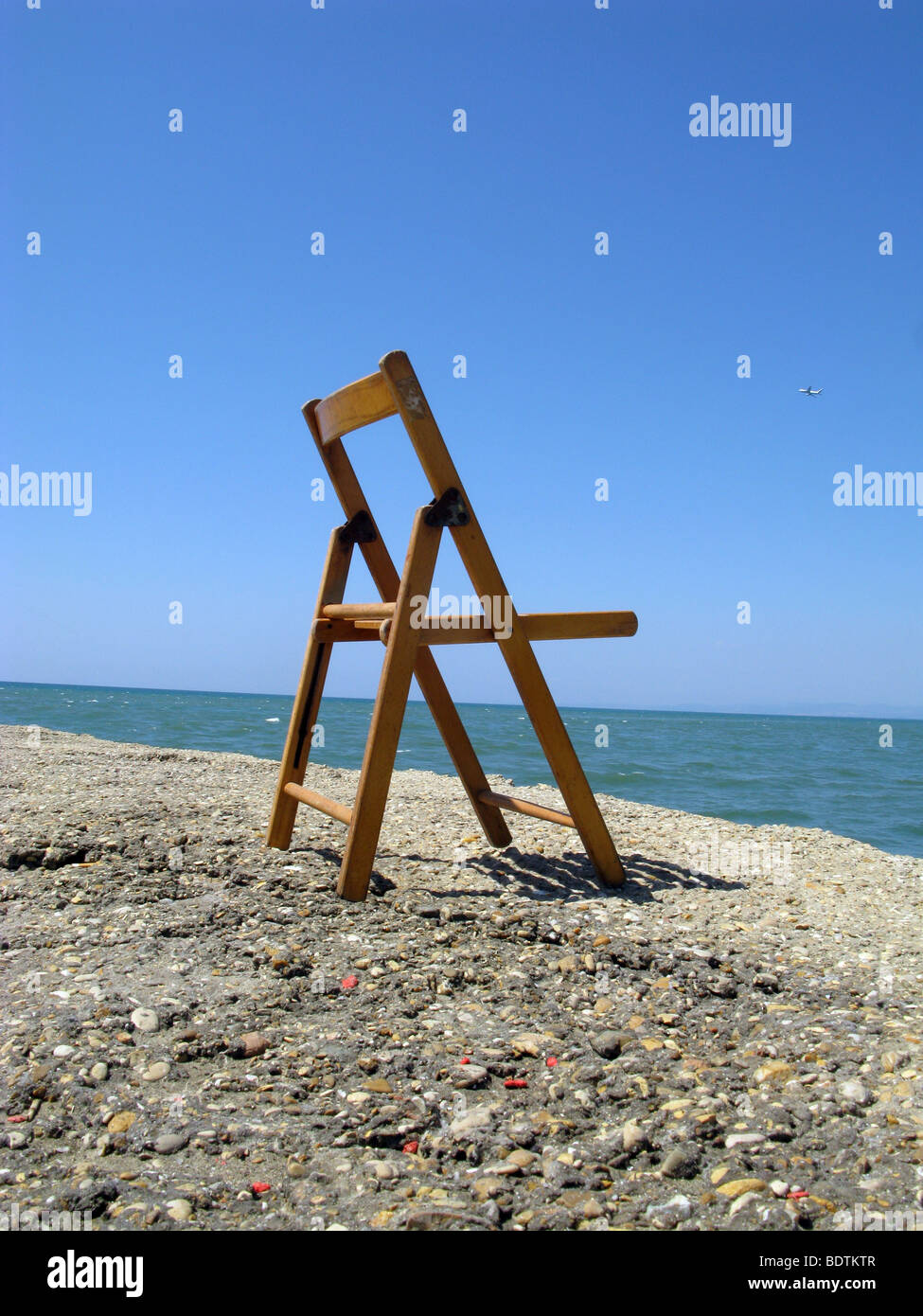 Ein Holzstuhl Meer in der Sonne Stockfoto