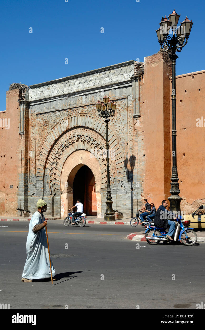 Ein marokkanischer Mann mit traditionellem Djellaba oder Jellaba geht am Bab Agnaou Tor (1188-1190) in der Stadt oder Stadtmauer von Marrakesch, Marokko vorbei Stockfoto
