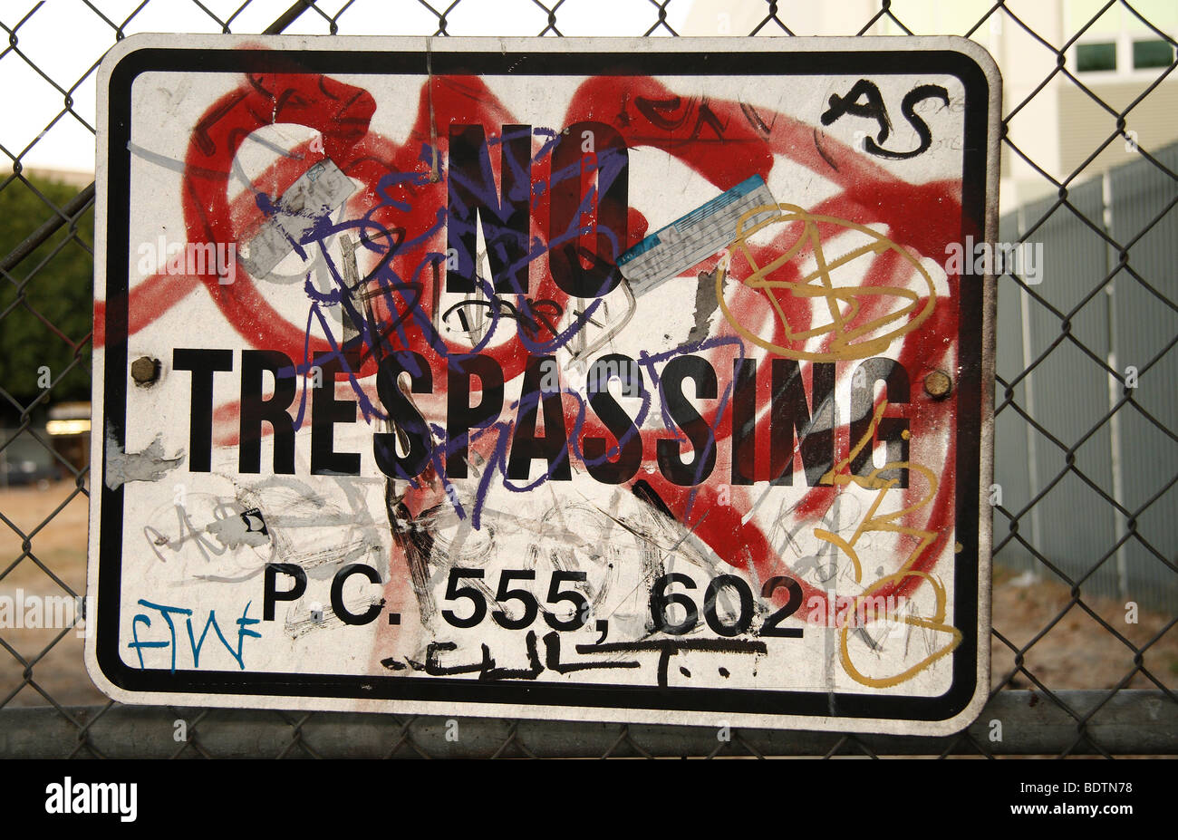 Kein Hausfriedensbruch Schild mit Graffiti geschrieben am Maschendrahtzaun Stockfoto