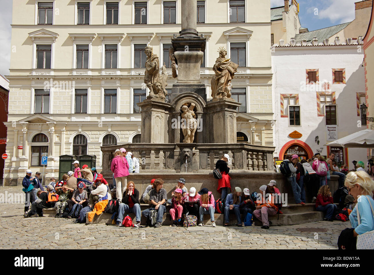 Schülerinnen und Schüler sitzen an der Mariensäule auf dem Marktplatz, Cesk Krumlov, Tschechische Republik, Europa Stockfoto