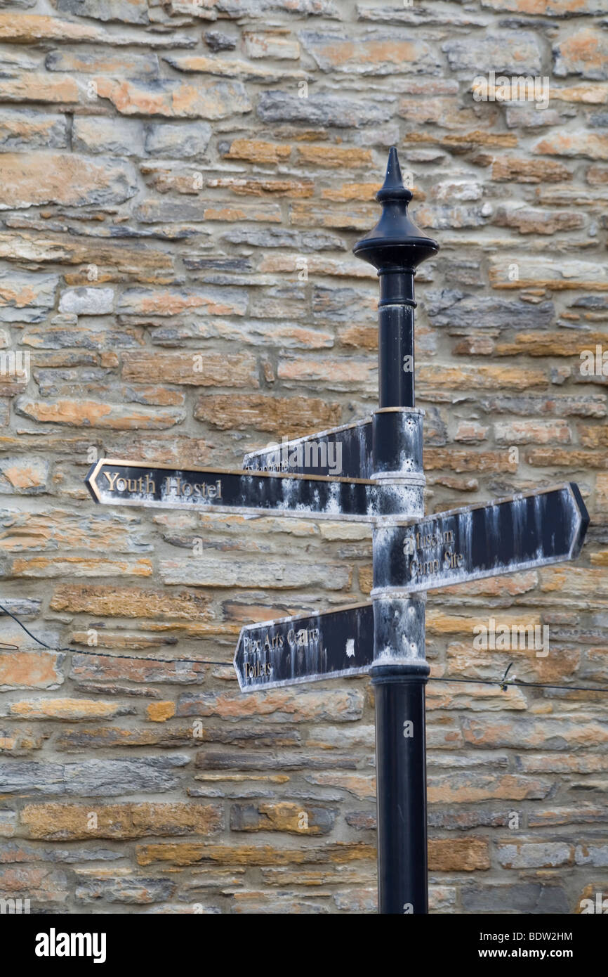 alten Wegweiser Vor Einer Bruchsteinmauer, Wegweiser zur Steinmauer, Orkney Inseln, Schottland Stockfoto