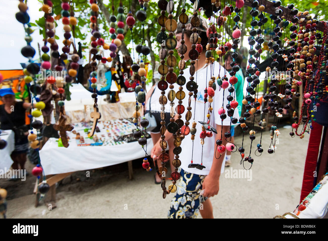 Touristen gehen vorbei an einem Stall zu verkaufen Souvenirs Perlen in Manuel Antonio nahe dem Eingang zum Nationalpark. Stockfoto