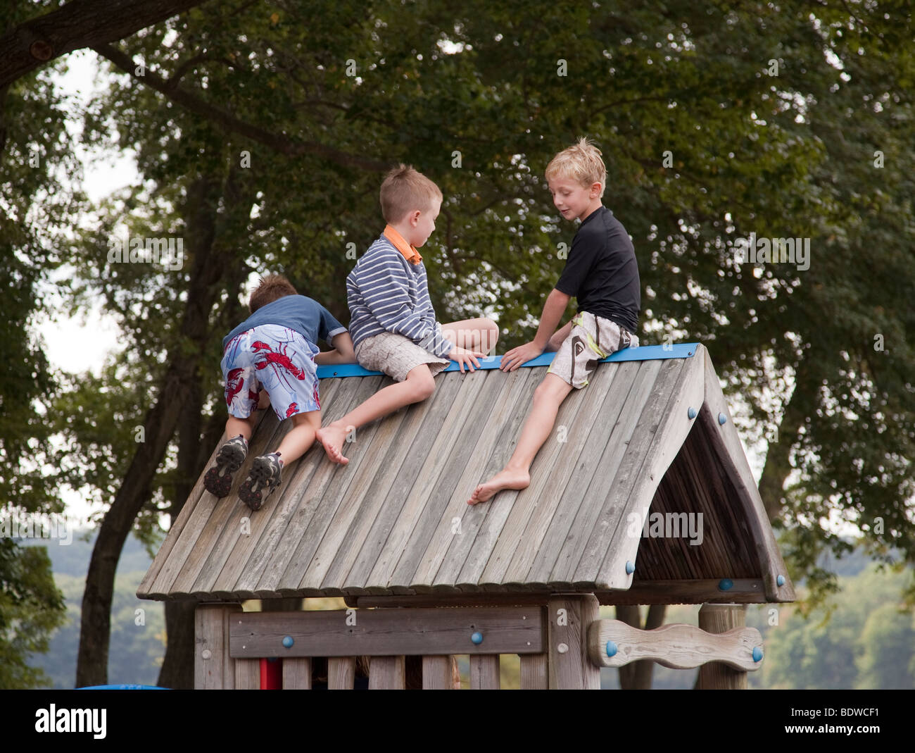 Drei Jungs Klettern auf dem Dach ein Spielhaus Stockfoto