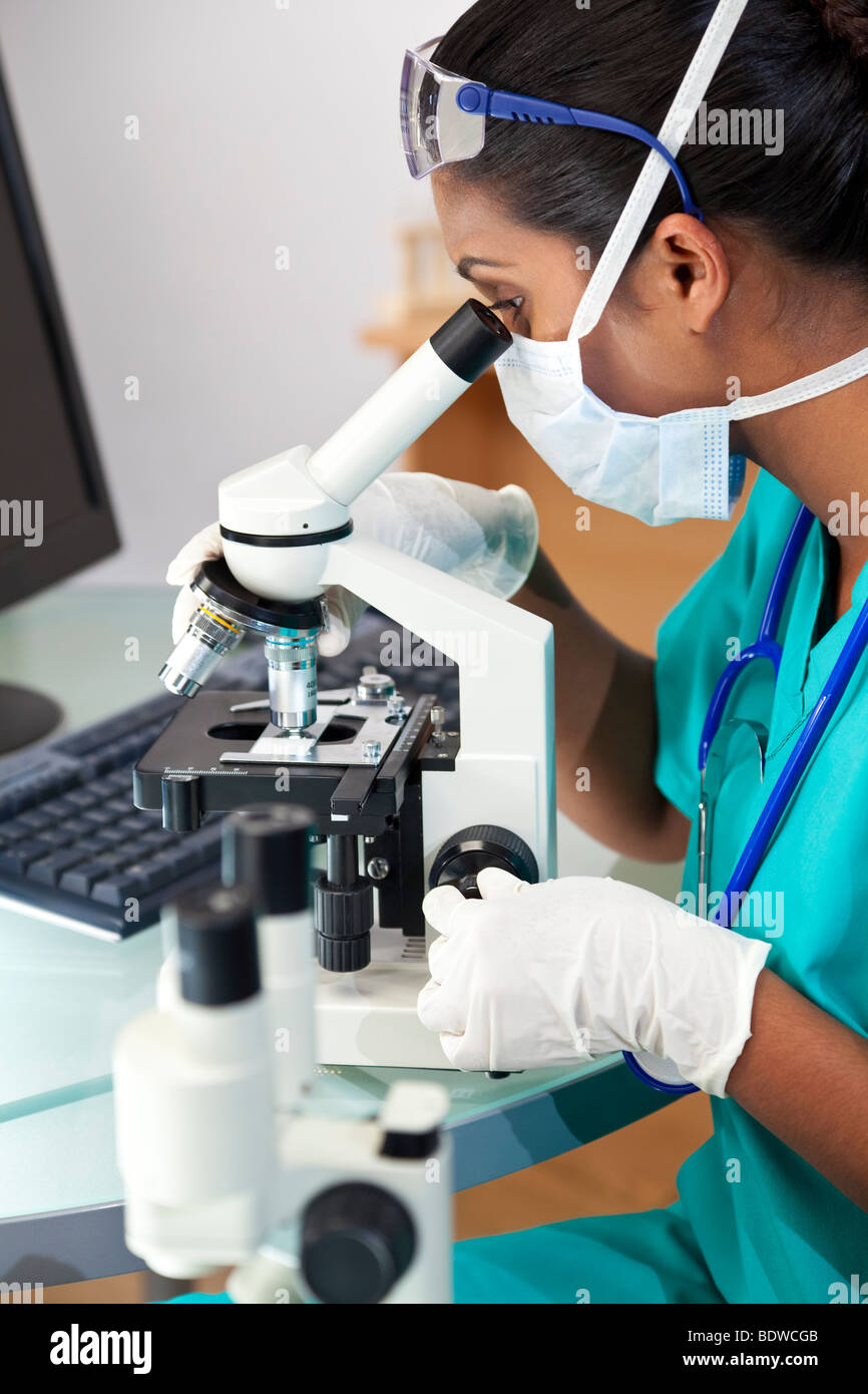 Eine asiatische Frauen Arzt oder wissenschaftlicher Mitarbeiter mit ihrem Mikroskop im Labor. Stockfoto