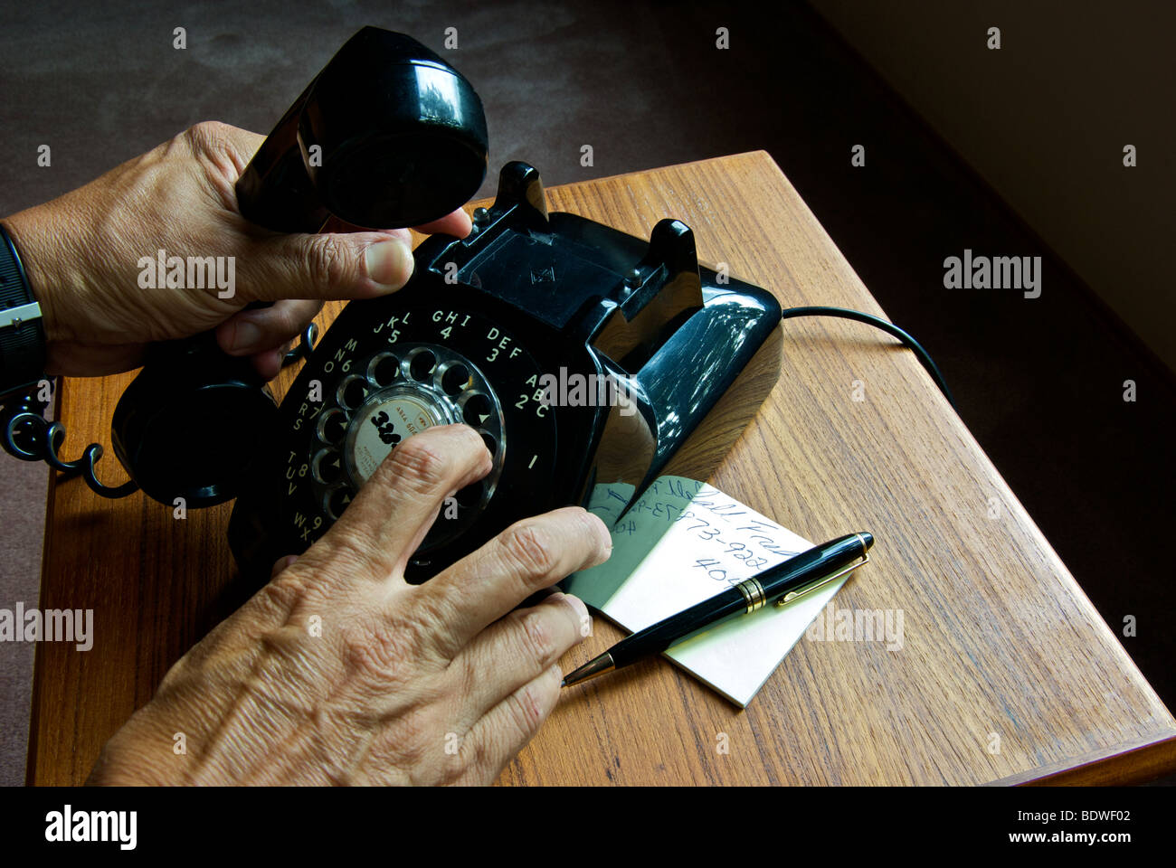 Veraltete Technik alte schwarze Rotary wählen Sie Telefon Hand mit Lautsprecher Hörer Finger wählen Telefonnummer Stockfoto
