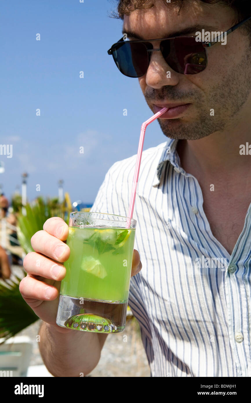 Mann mittleren Alters in Gläsern trinken cocktail Mojito am Strand Stockfoto