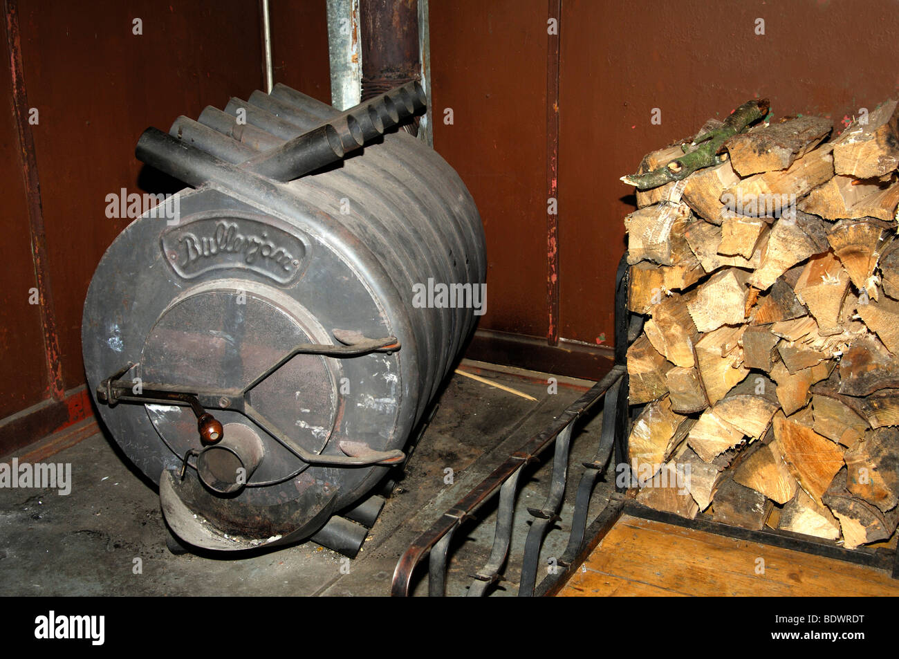 Heißluft-Ofen Bullerjan und ein Haufen Brennholz Protokolle Stockfotografie  - Alamy