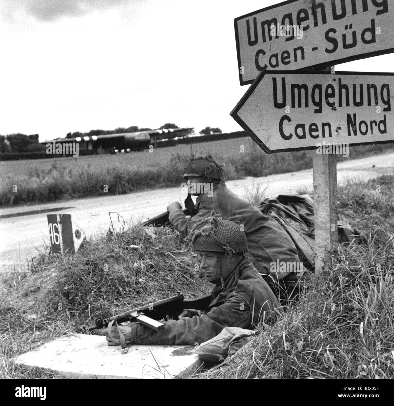 INVASION DER NORMANDIE. Zwei Mitglieder der 6. Airborne, bewaffnet mit Sten-Geschützen, bewachen eine Kreuzung am Stadtrand von Caen als Teil der Operation Goodwood Stockfoto