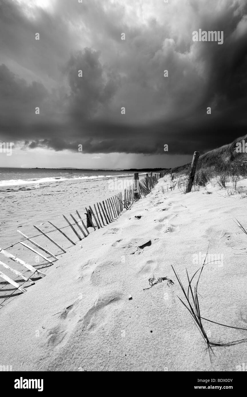 Dramatischen Blick auf Wolken sammeln über die Dünen und der schöne Strand von Penrhyn Llyn, Wales Stockfoto