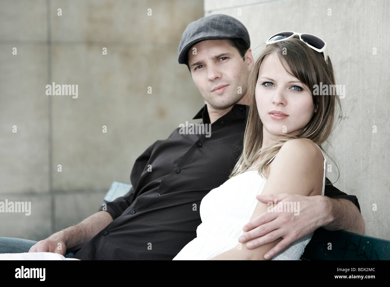 Junges Paar sitzen zusammen auf einer Parkbank Stockfoto