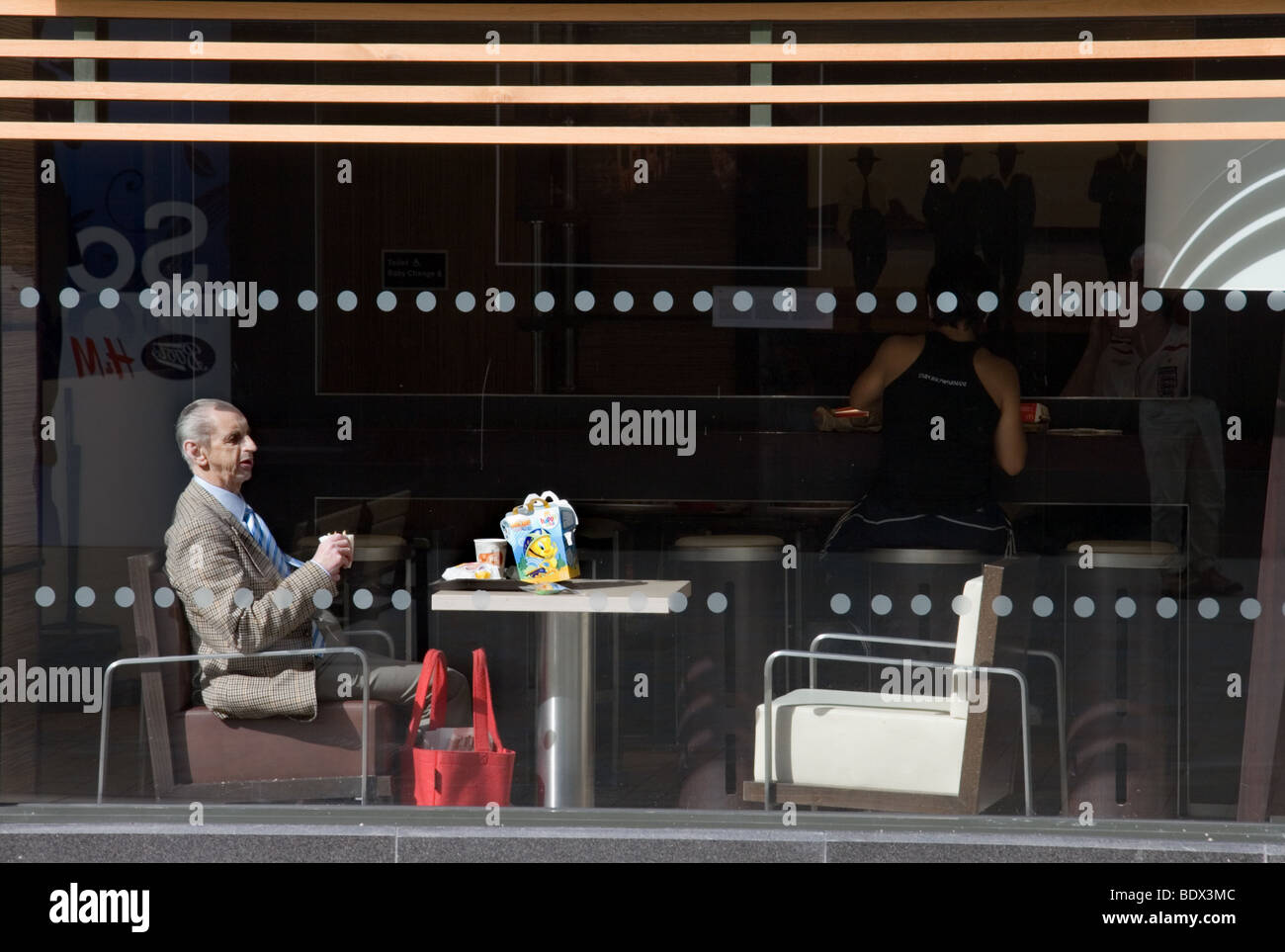 Ein Mann sitzt am Fenster eines Cafés Stockfoto