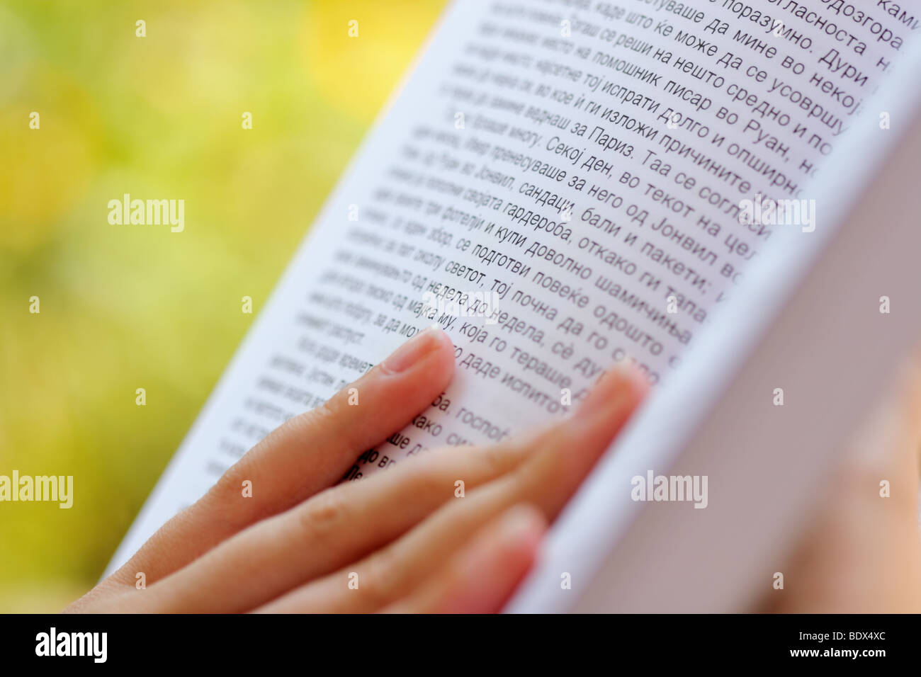 weibliche Hand hält ein kyrillisches Alphabet Buch, im freien Stockfoto