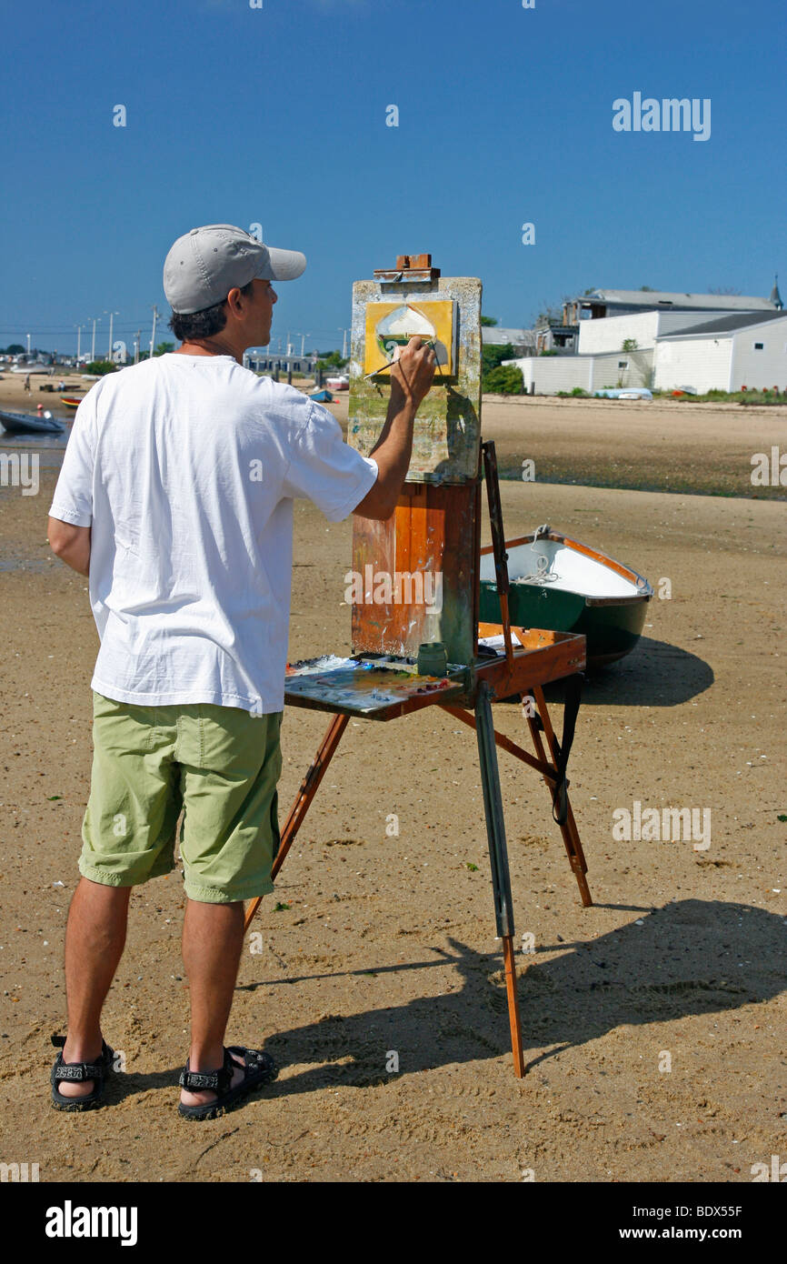 Männliche Künstler Malerei ein Boot am Strand in Provincetown, Massachusetts. Stockfoto