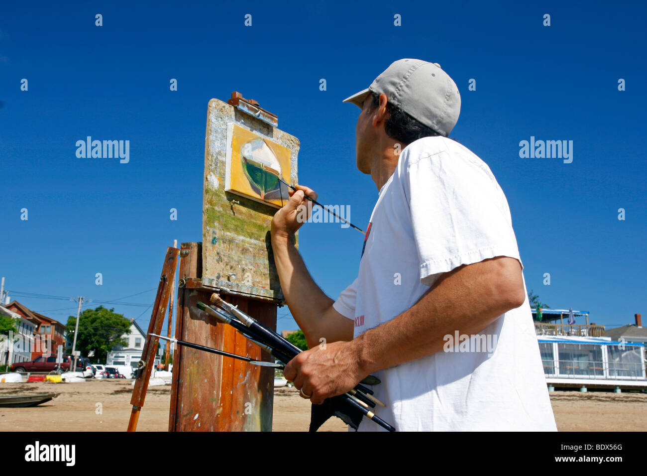 Männliche Künstler Malerei ein Boot am Strand in Provincetown, Massachusetts. Stockfoto