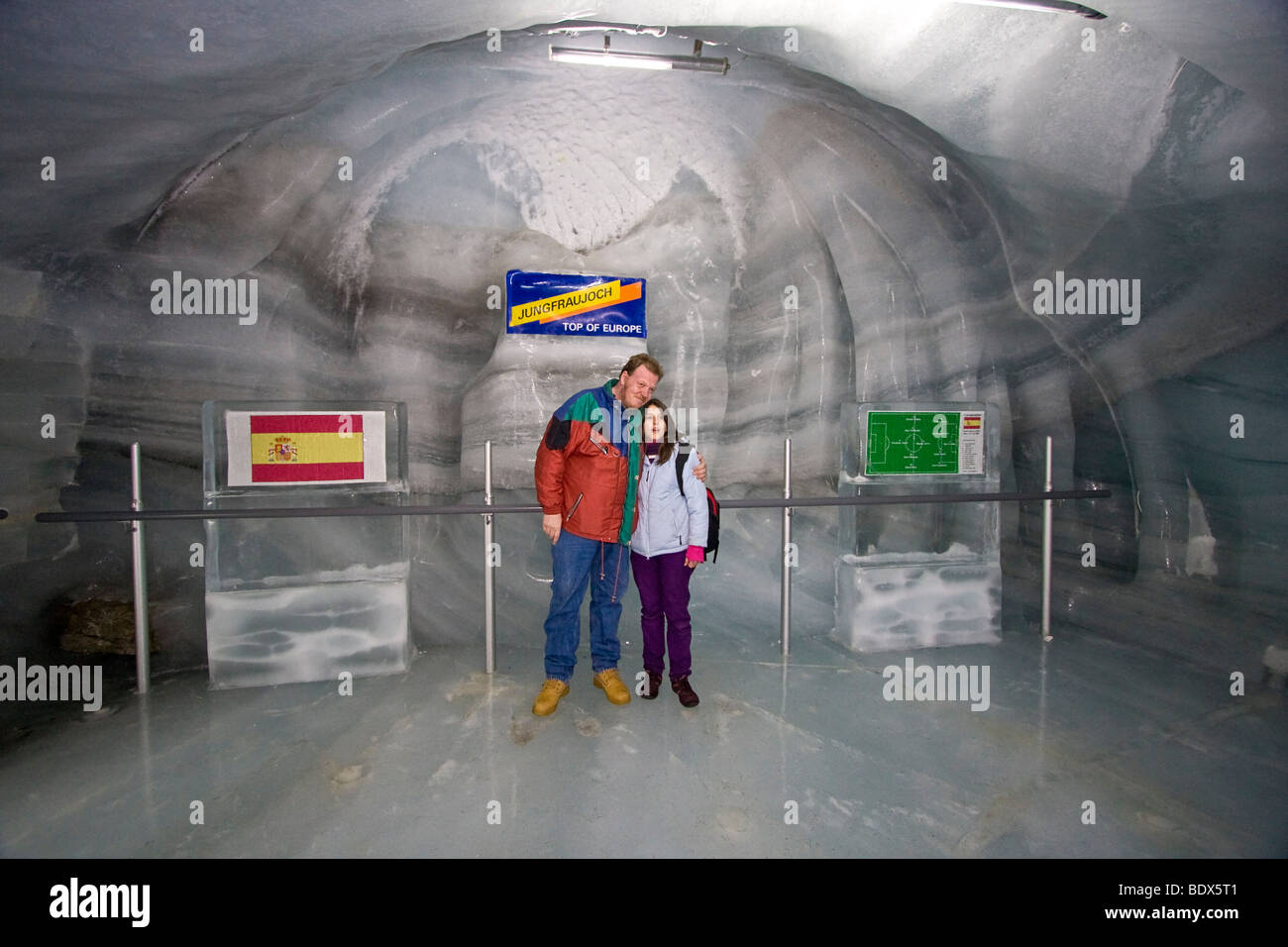 Paar Posen im Eispalast mit Eis Schnitzereien am Jungfraujoch, das Ende der Zeile die Zugstrecke von Grindelwald. Stockfoto