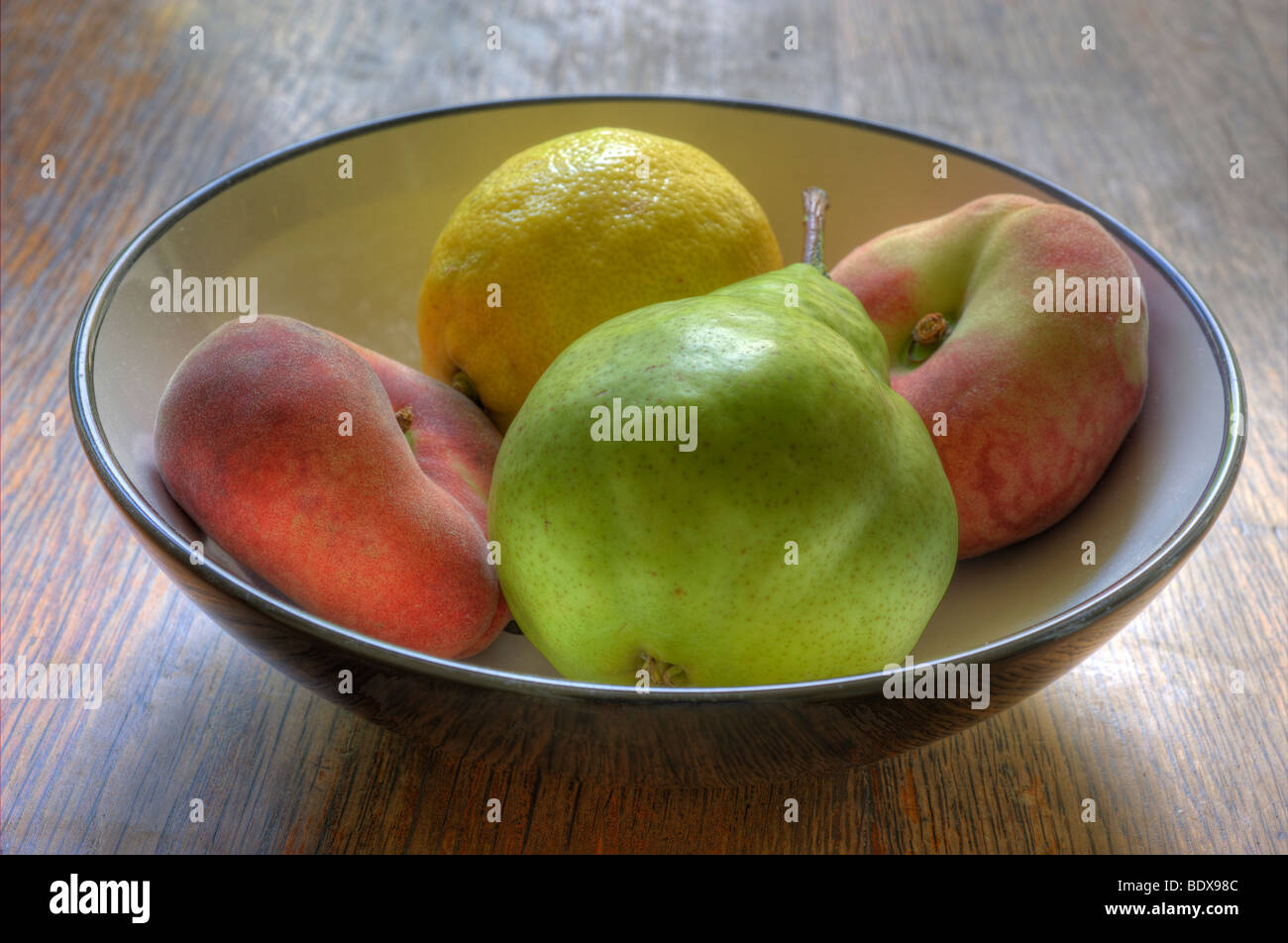 Schale mit weißem Pfirsich, Birne und eine Zitrone Stockfoto