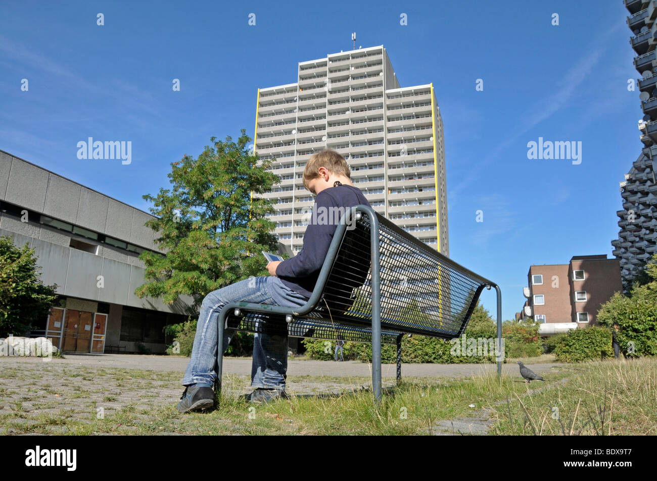Junge, Sat 9, spielt mit seinem Nintendo vor einem Hochhaus Wohnung Stadt Chorweiler in Köln Nord Rh Stockfoto
