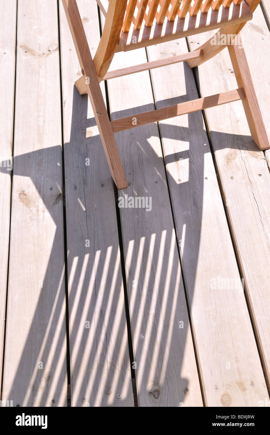 Holzstuhl werfen einen Schatten auf einer Terrasse Boden Stockfoto