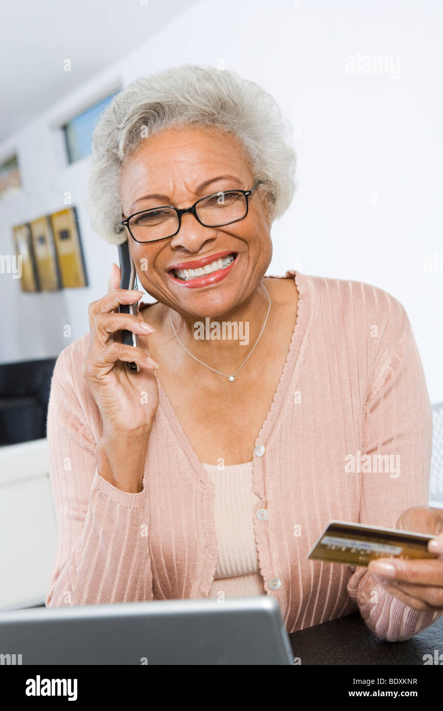 Fröhliche Senior Frau mit Laptop, halten Kreditkarte Stockfoto