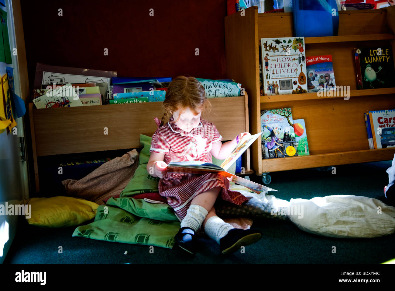 Mädchen lesen allein in einem Klassenzimmer der Grundschule Stockfoto