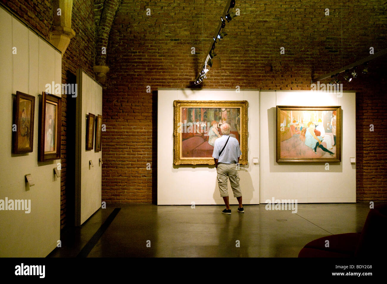 Innerhalb einer Galerie von Albi Toulouse-Lautrec starrt Museum ein Besucher auf zwei Versionen eines der berühmtesten Gemälde des Künstlers Stockfoto
