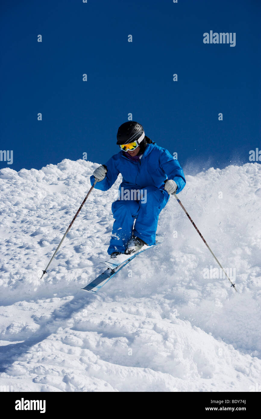 Mann im blauen Ski bergab. Stockfoto