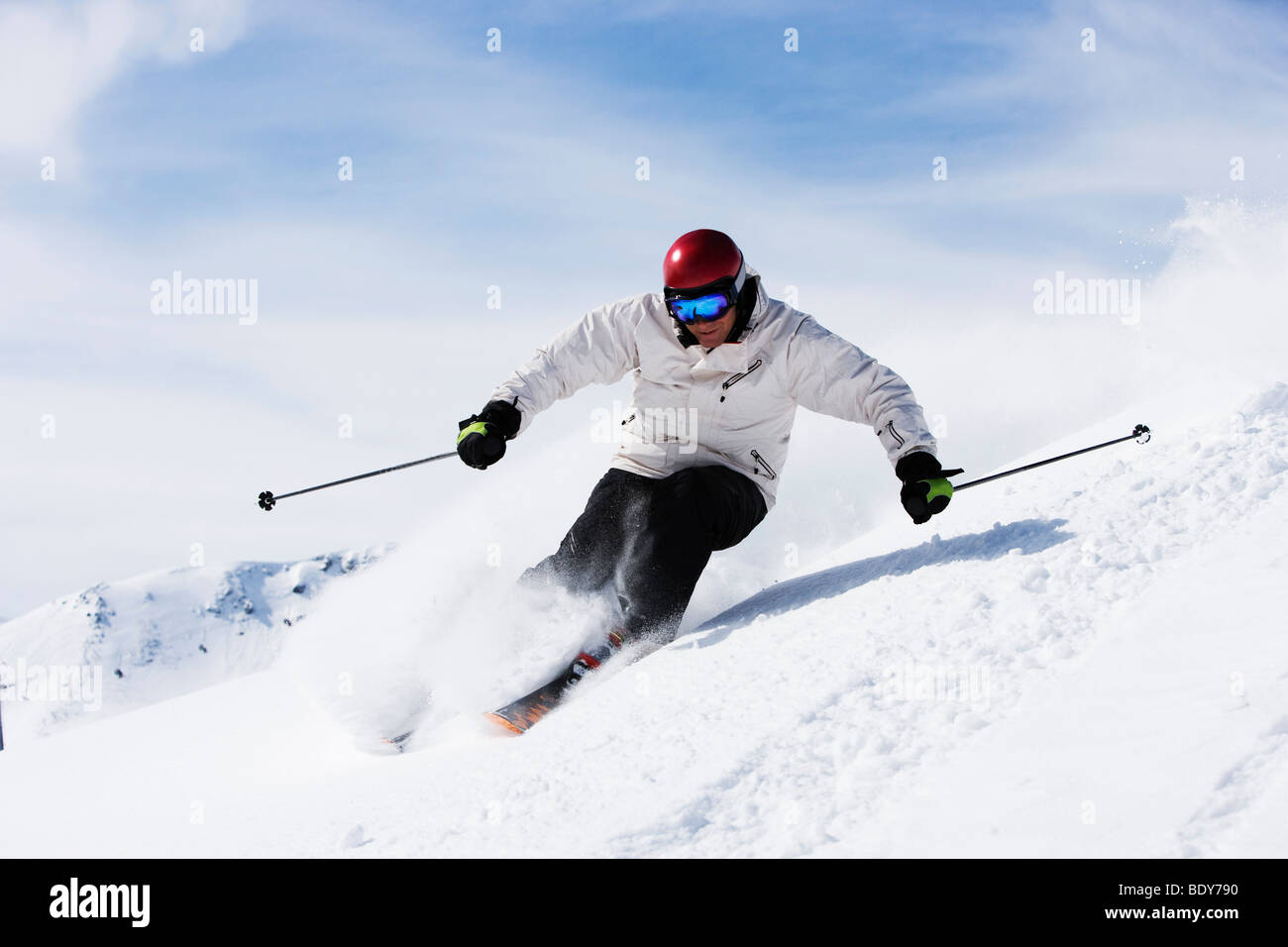 Mann in weiß mit roten Helm abseits der Piste. Stockfoto