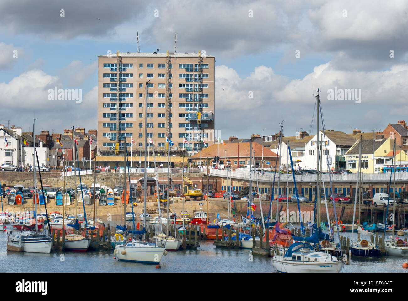 Bridlington Hafen, East Yorkshire, England, UK mit einem Hochhaus im Hintergrund Stockfoto