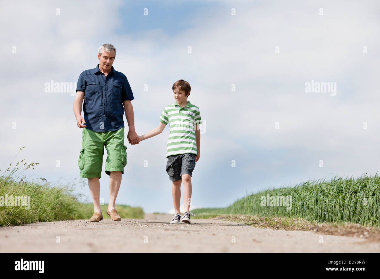 Vater und Sohn zu Fuß eine Straße hinunter Stockfoto