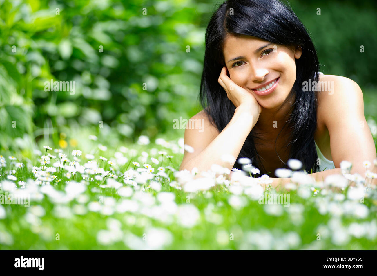 Lächelnde Frau in die Gänseblümchen Stockfoto