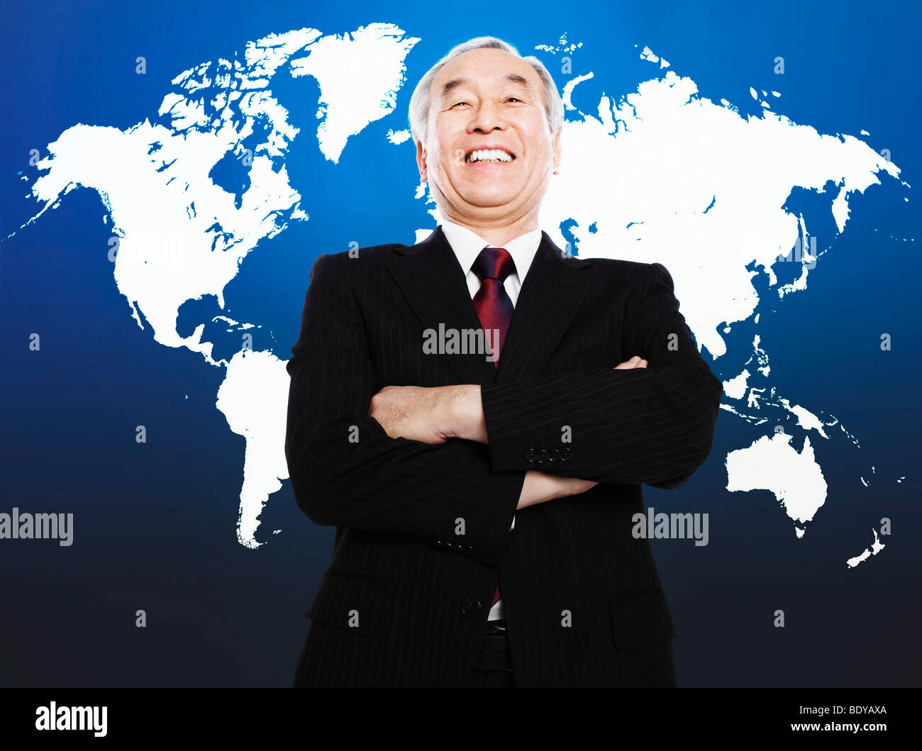 Asiatischer Mann lächelnd vor Weltkarte Stockfoto