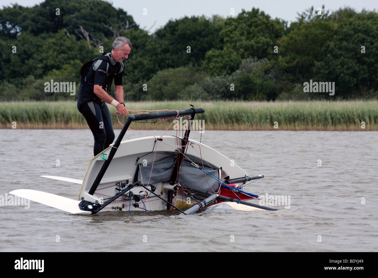 Segler, die versuchen, seine Jolle auf Hickling Broad rechts Stockfoto