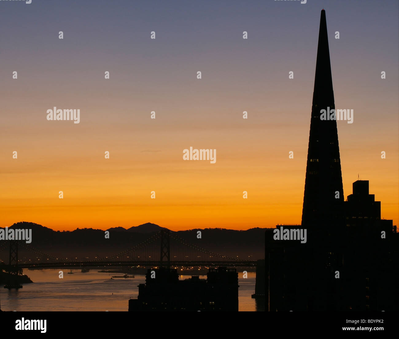 Die Transamerica Pyramid und Bucht Brücke San Francisco bei Sonnenaufgang. Stockfoto