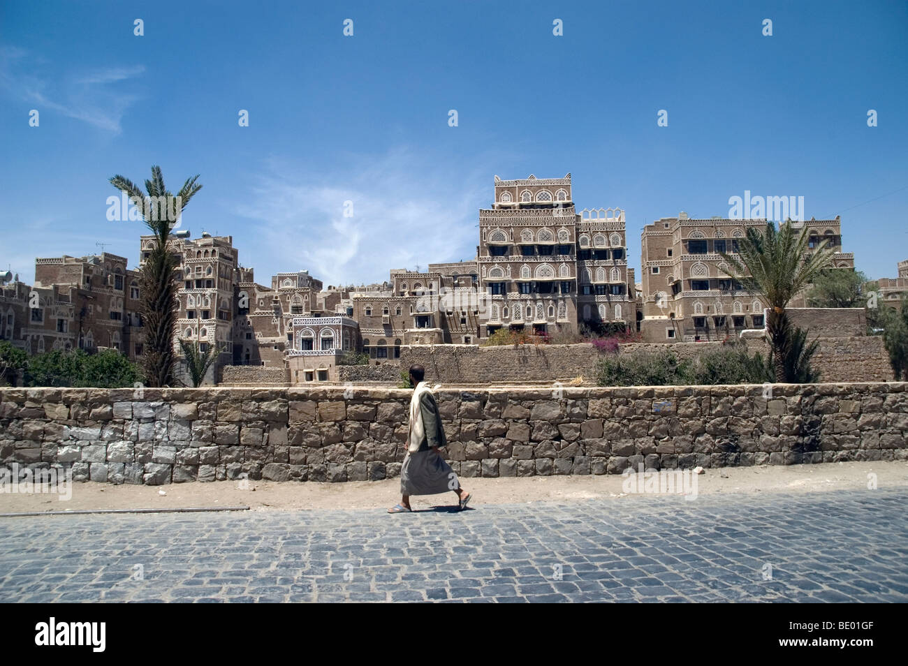 Ein Mann schlendert Vergangenheit Turm befindet sich in der Fußgängerzone der Altstadt von Sana'a, Jemen. Stockfoto