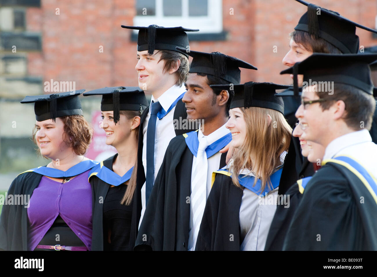 Absolventinnen und Absolventen posieren für Fotografen am Abschlusstag Stockfoto